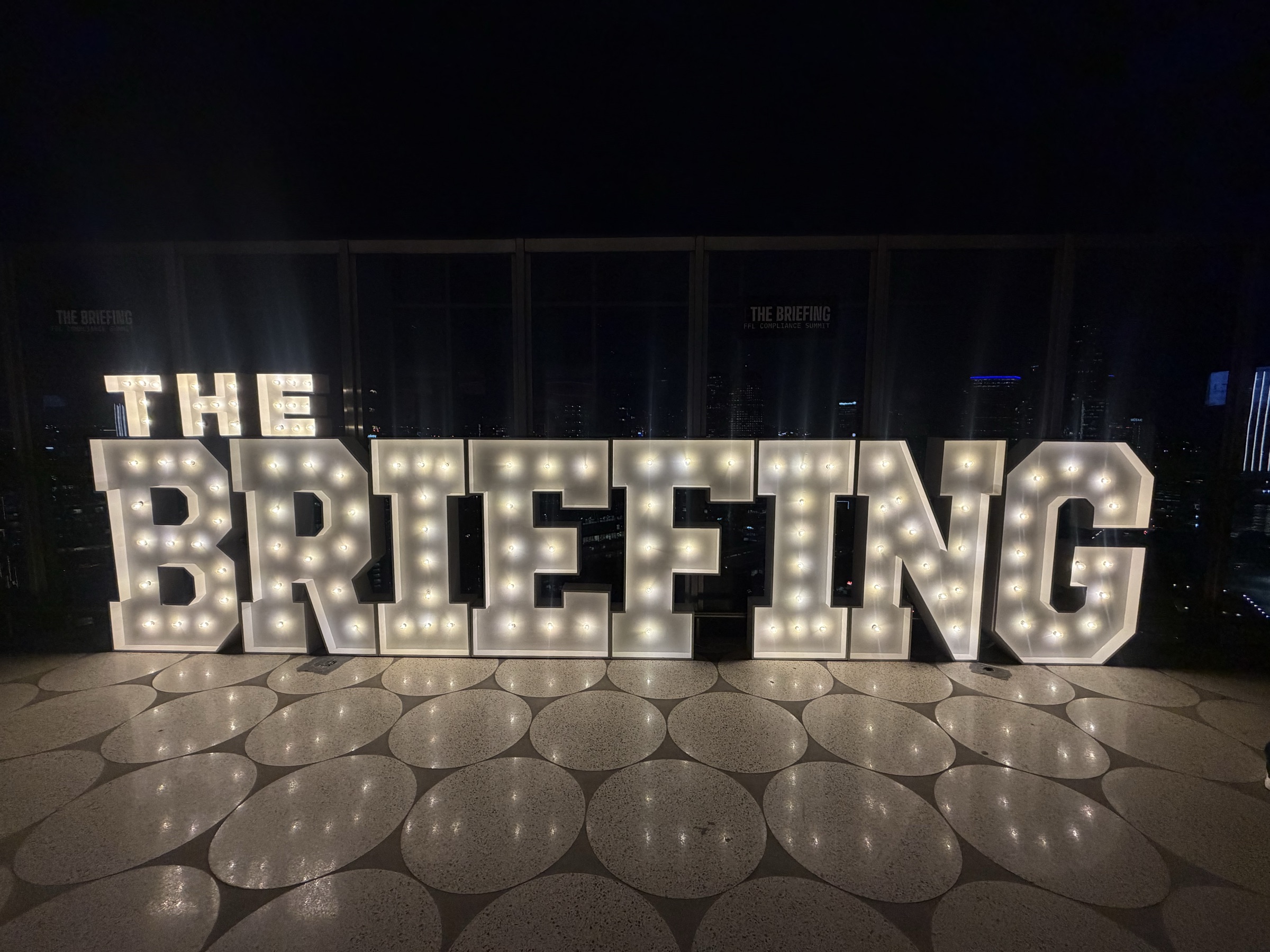 The lit “THE BRIEFING” marquee at night