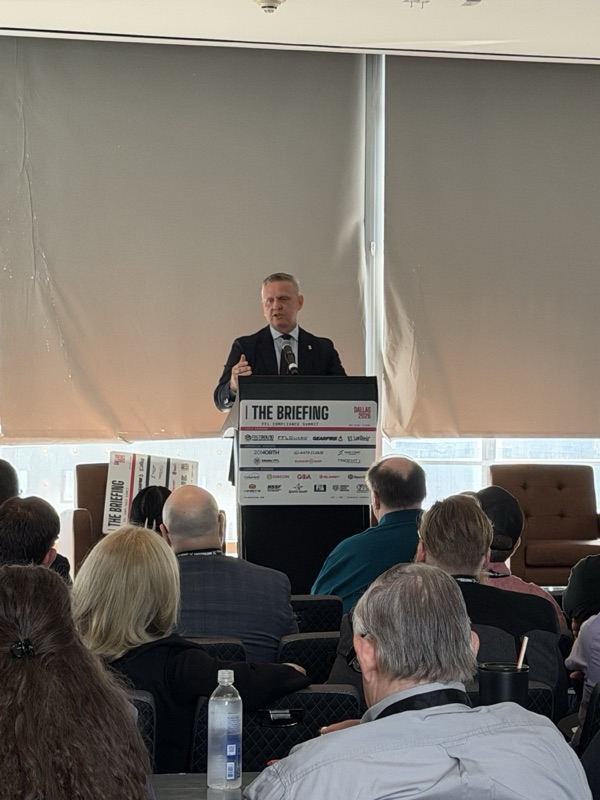 ATF Director Rob Cekada speaking from The Briefing podium during his keynote, “The New Era of FFL Compliance,” with the audience in the foreground