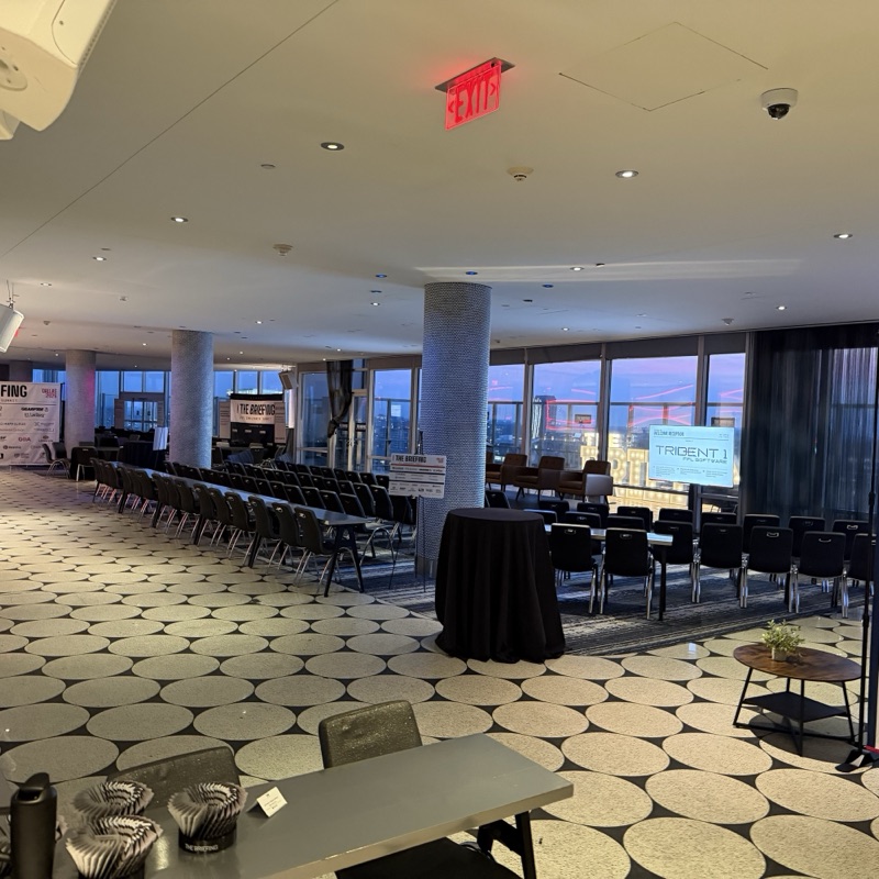 An empty session room set up before doors, with a Trident 1 welcome screen